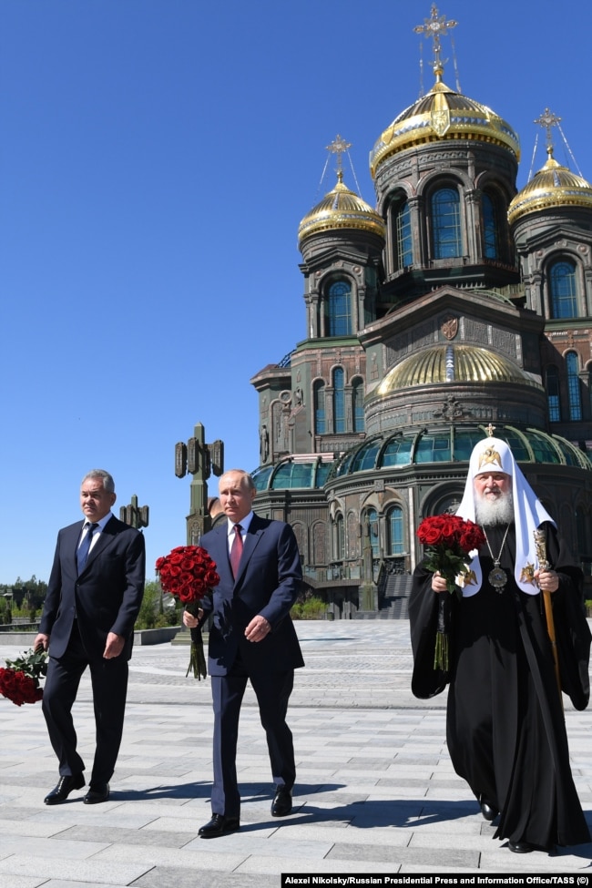 Ексміністр оборони РФ Сергій Шойгу, російський керманич Володимир Путін та Московський патріарх Кирило біля храму на території військово-патріотичного парку культури та відпочинку збройних сил РФ &laquo;Патріот&raquo;
